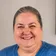 Irma, owner of De La Mora Cleaning Services, smiling warmly in a blue shirt